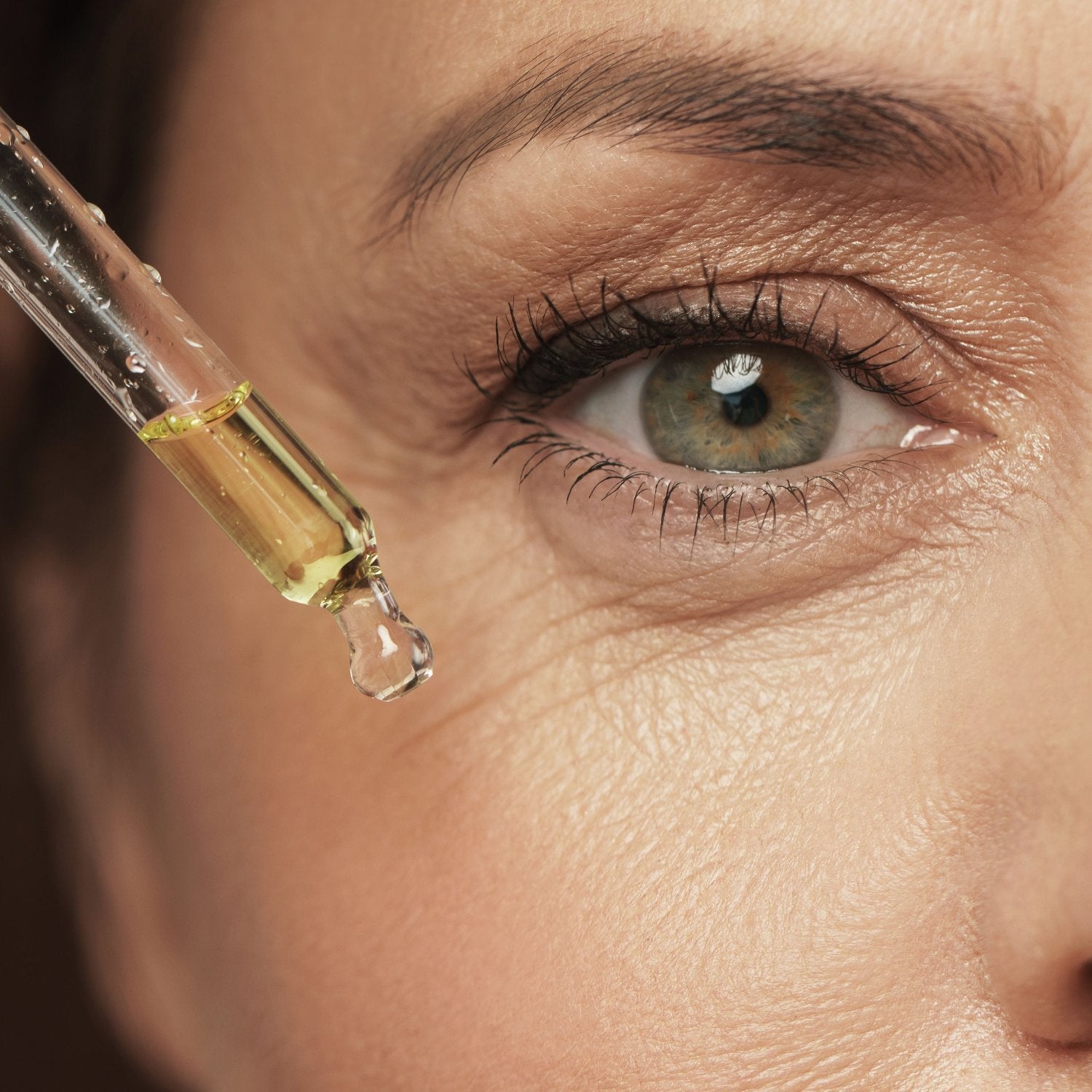 donna che applica sul viso olio di canapa per la pelle