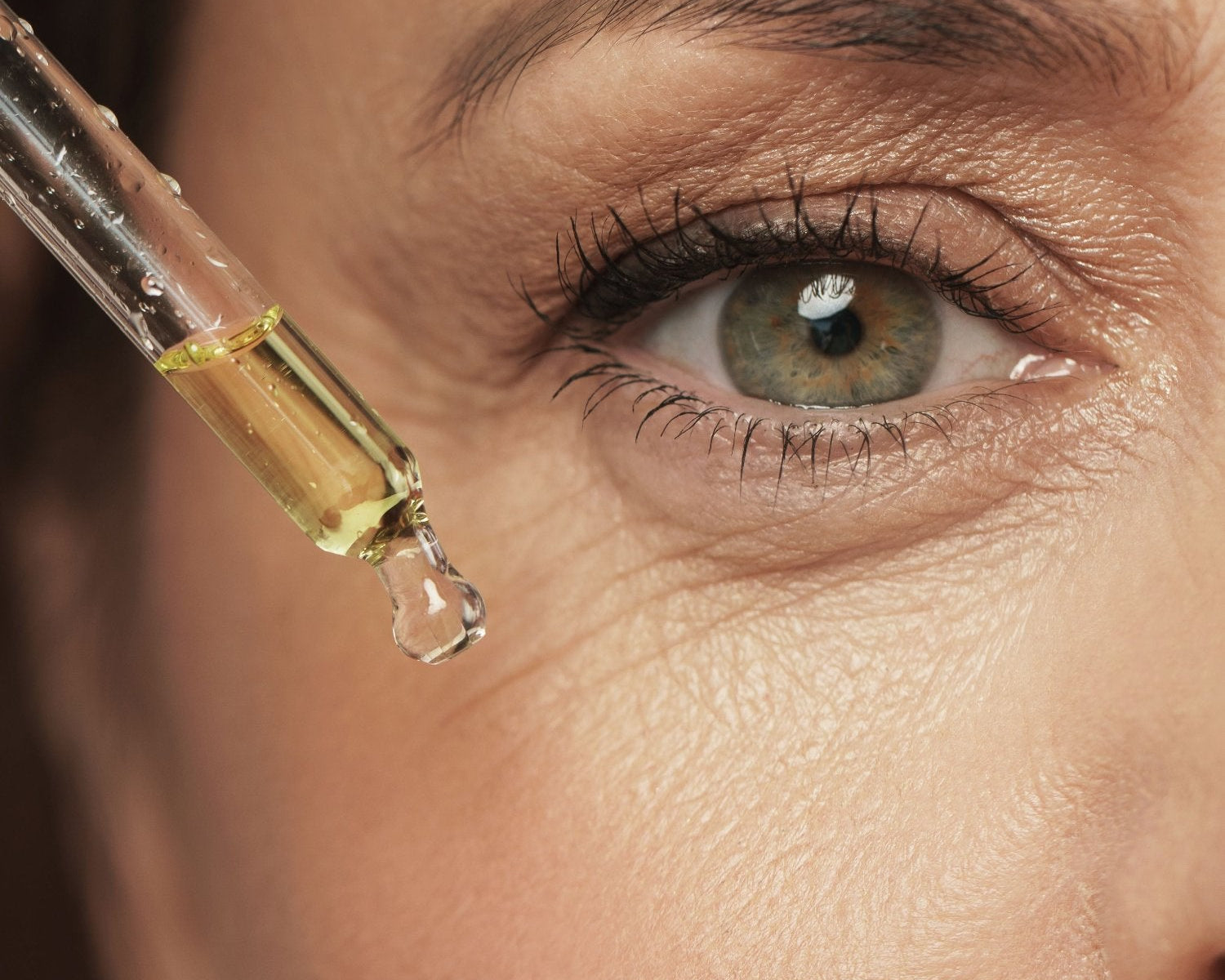 donna che applica sul viso olio di canapa per la pelle