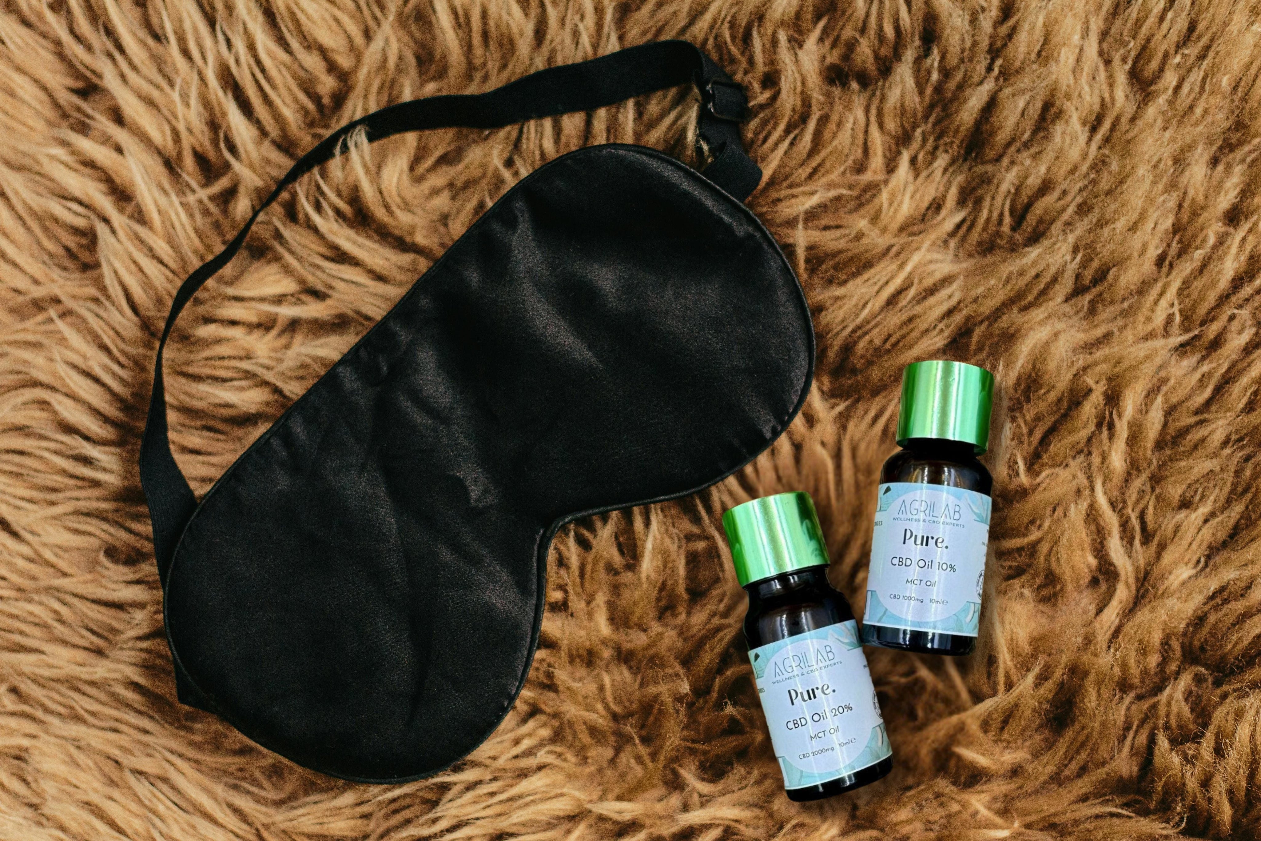 olio di cbd isolato 20% agrilab su sfondo tappeto stile peloso e maschera per dormire 