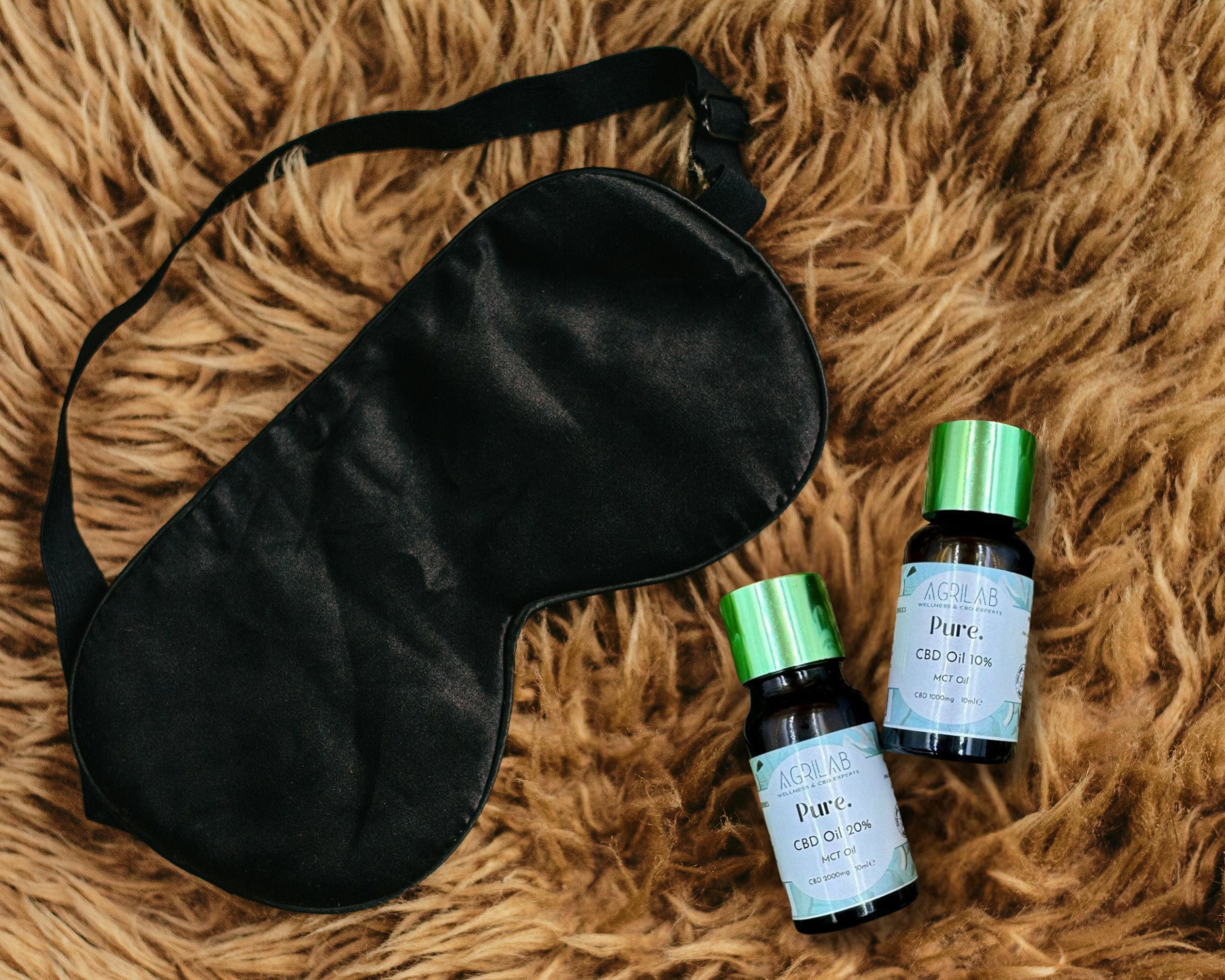 olio di cbd isolato 20% agrilab su sfondo tappeto stile peloso e maschera per dormire 