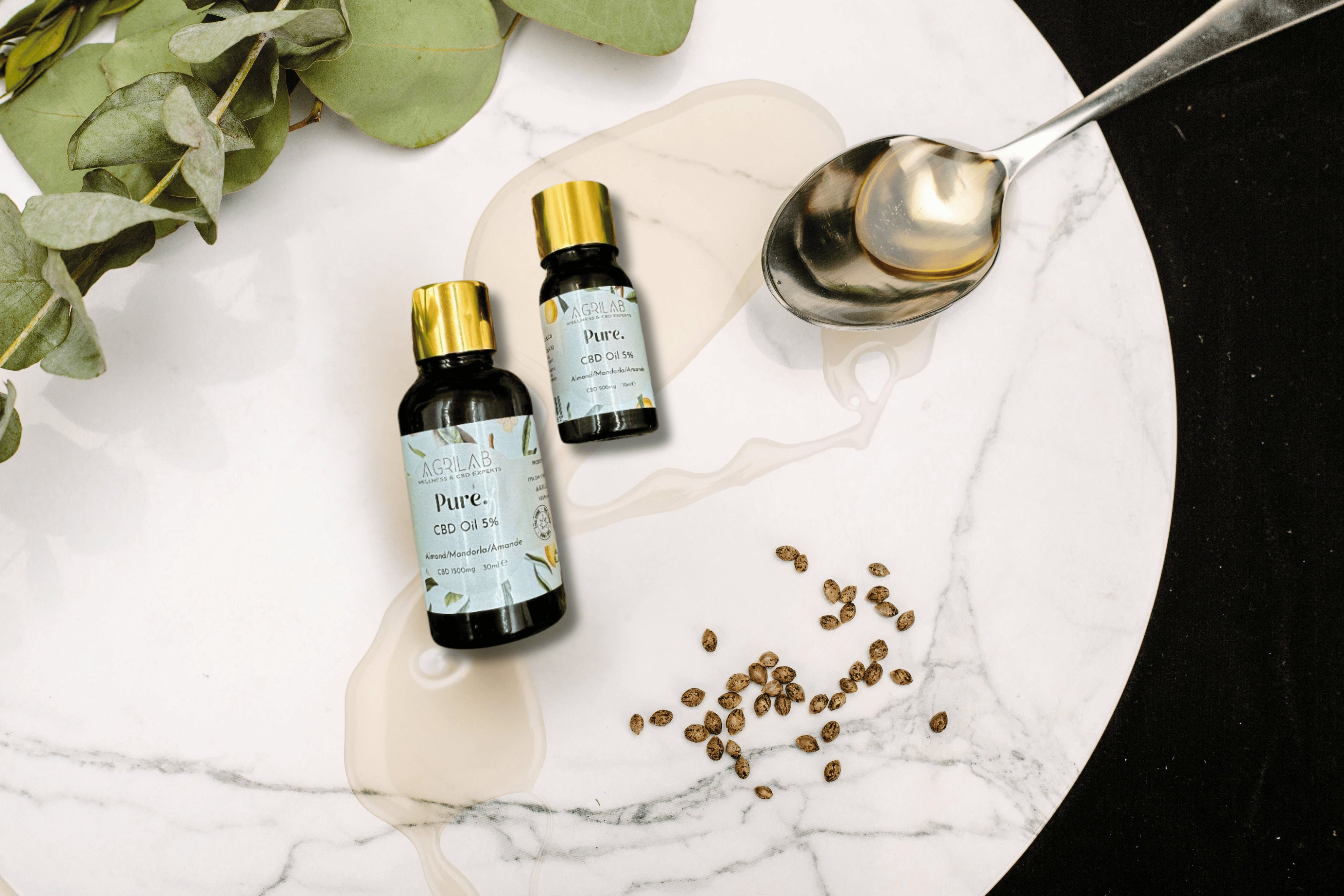 olio di cbd isolato 5% e mandorla agrilab su sfondo marmoreo e vegetazione