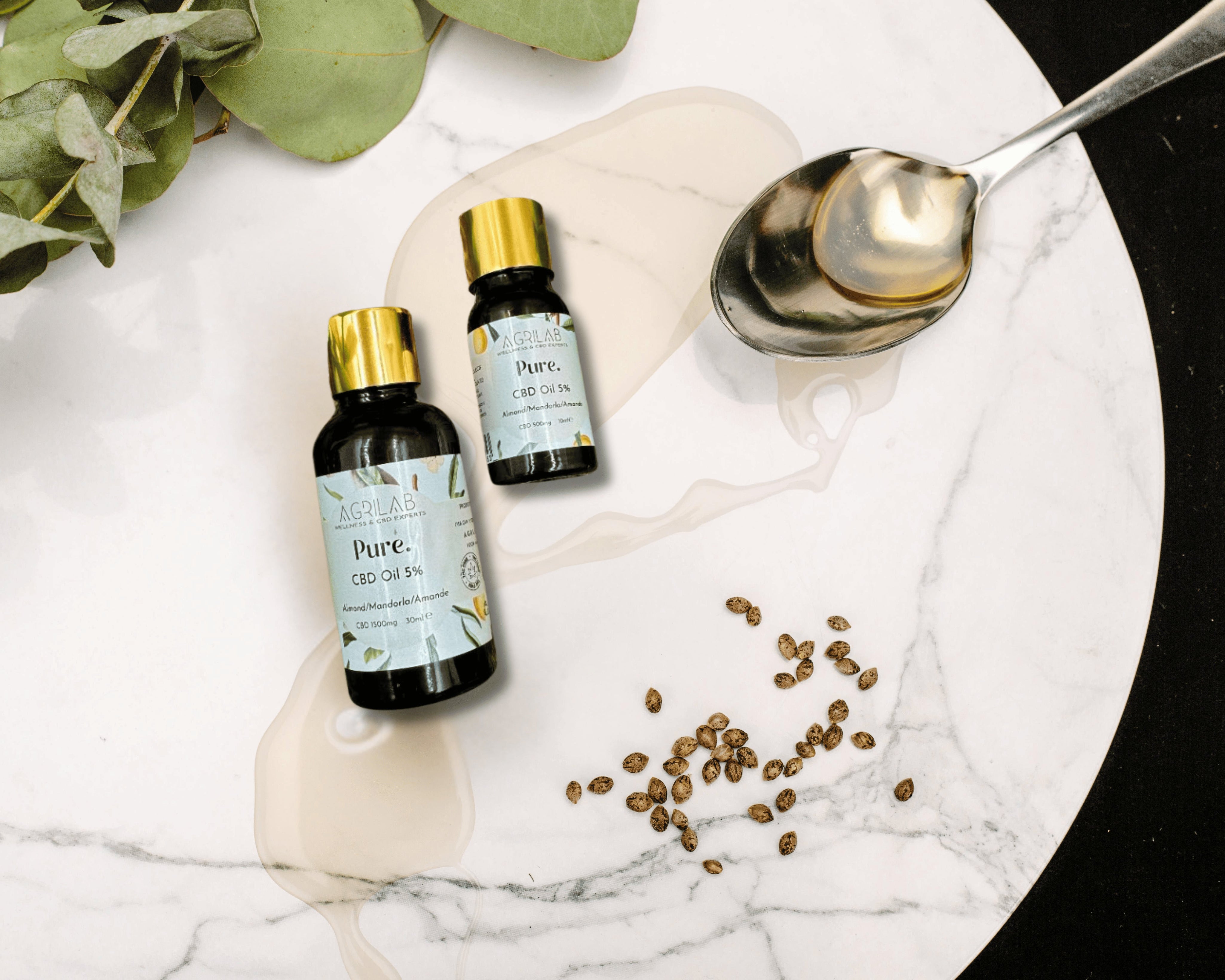 olio di cbd isolato 5% e mandorla agrilab su sfondo marmoreo e vegetazione