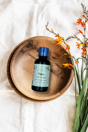 boccetta da 30 ml cristalli puri CBD olio vettore di canapa su ciotola di legno su panno bianco steli fiori arancioni accanto  agrilab-shop.myshopify.com product_type AGRILAB SHOP