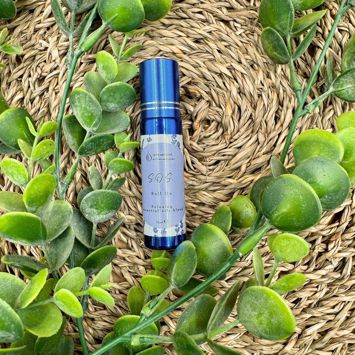 sos roll on cbd stick da 10 ml blu su sfondo di paglia e pianta verde grassa